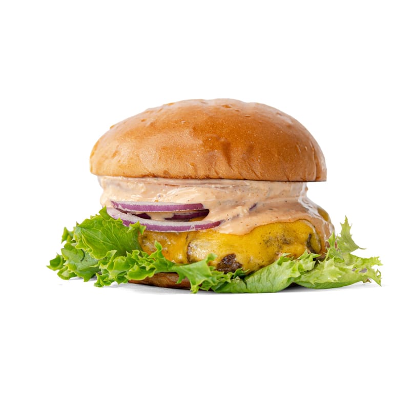 Cheeseburger with lettuce, red onion, and special sauce on a brioche bun, isolated on white.